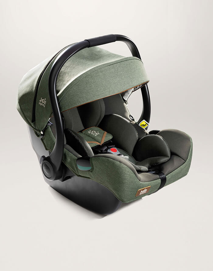 A green Joie i-Jemini infant car seat at an angle facing to the right