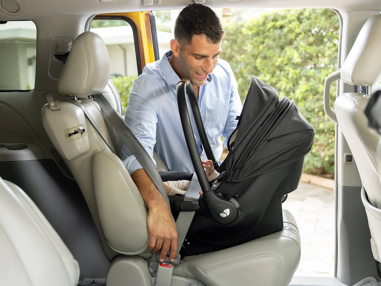 Dad next to baby in mint latch in shale installed with vehicle seat belt. 
