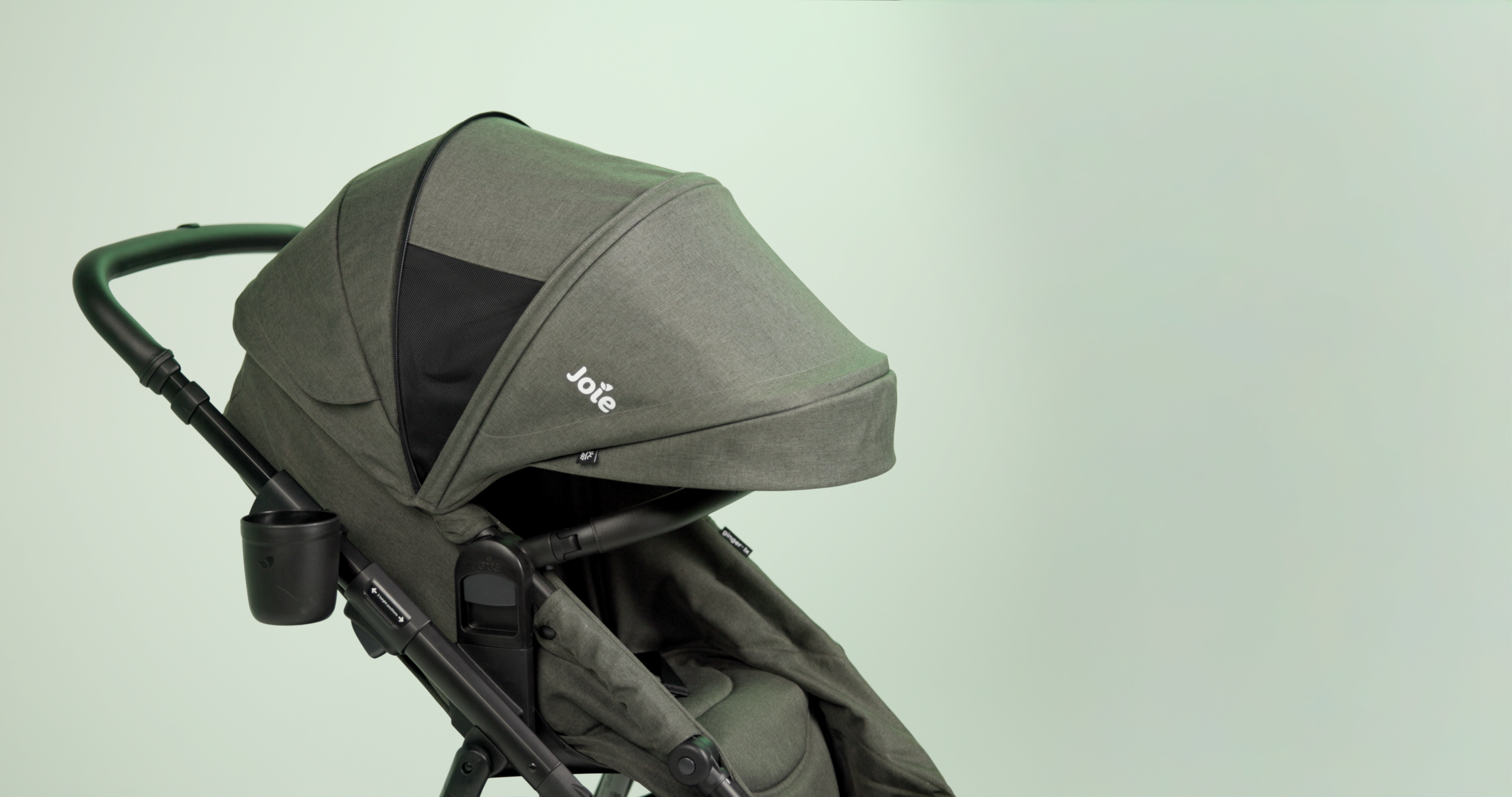 Profile angle ginger lx stroller in evergreen showing extended canopy feature on green background