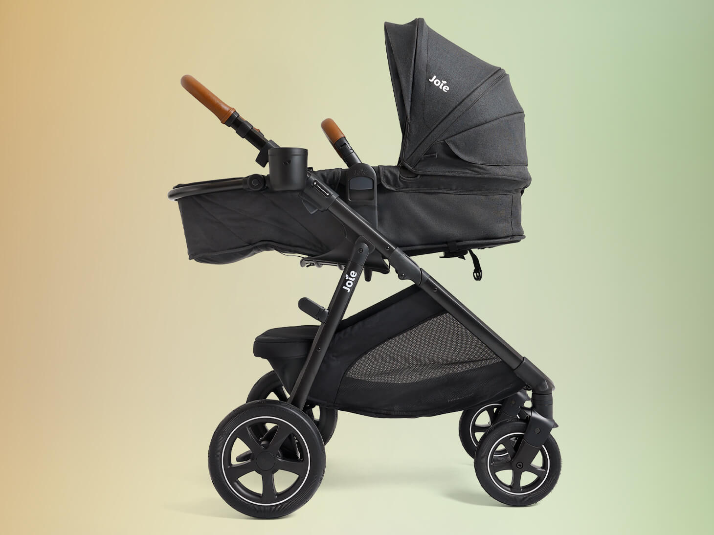 Ginger DLX in black in pramette mode on yellow to green gradient background.