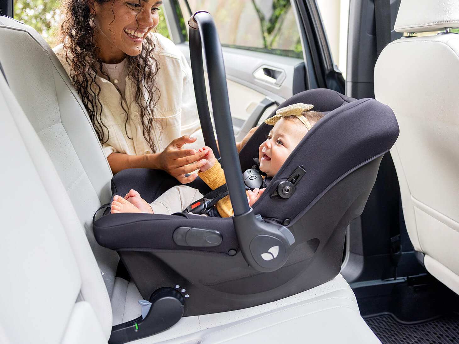 Lifestyle photos of mom next to baby in car in Mint Latch baseless infant car seat. 
