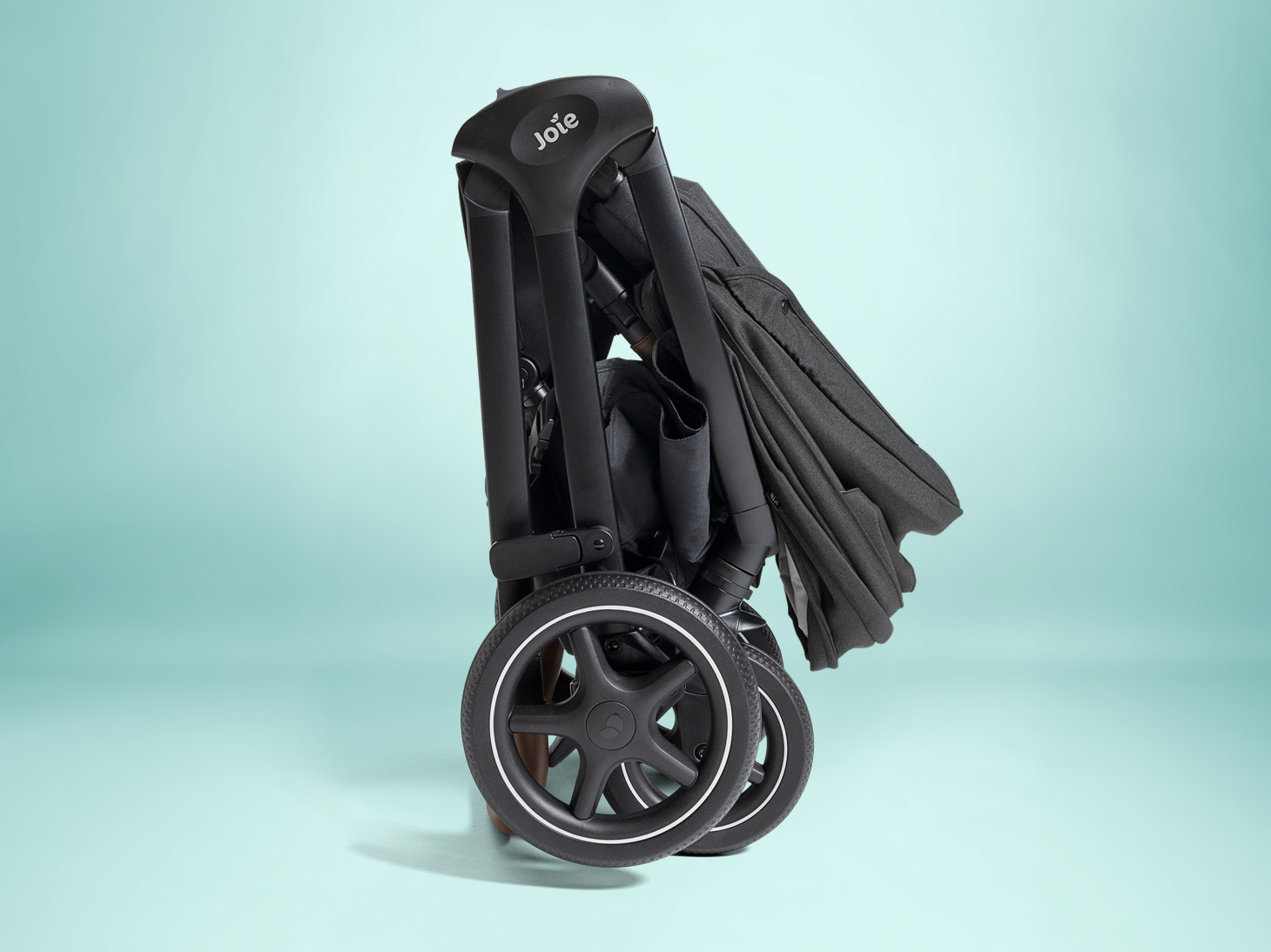 Folded angle of Kava stroller on teal background