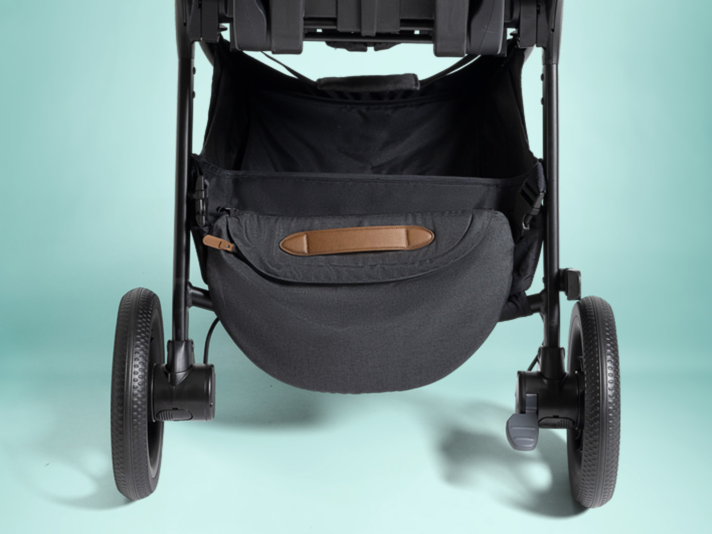 Close up of detachable crossbody bag on Kava stroller on teal background