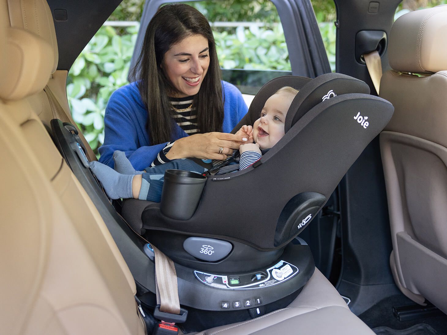 Mom buckling baby in to chili spin SI 2-in-1 rotating car seat rear-facing in car