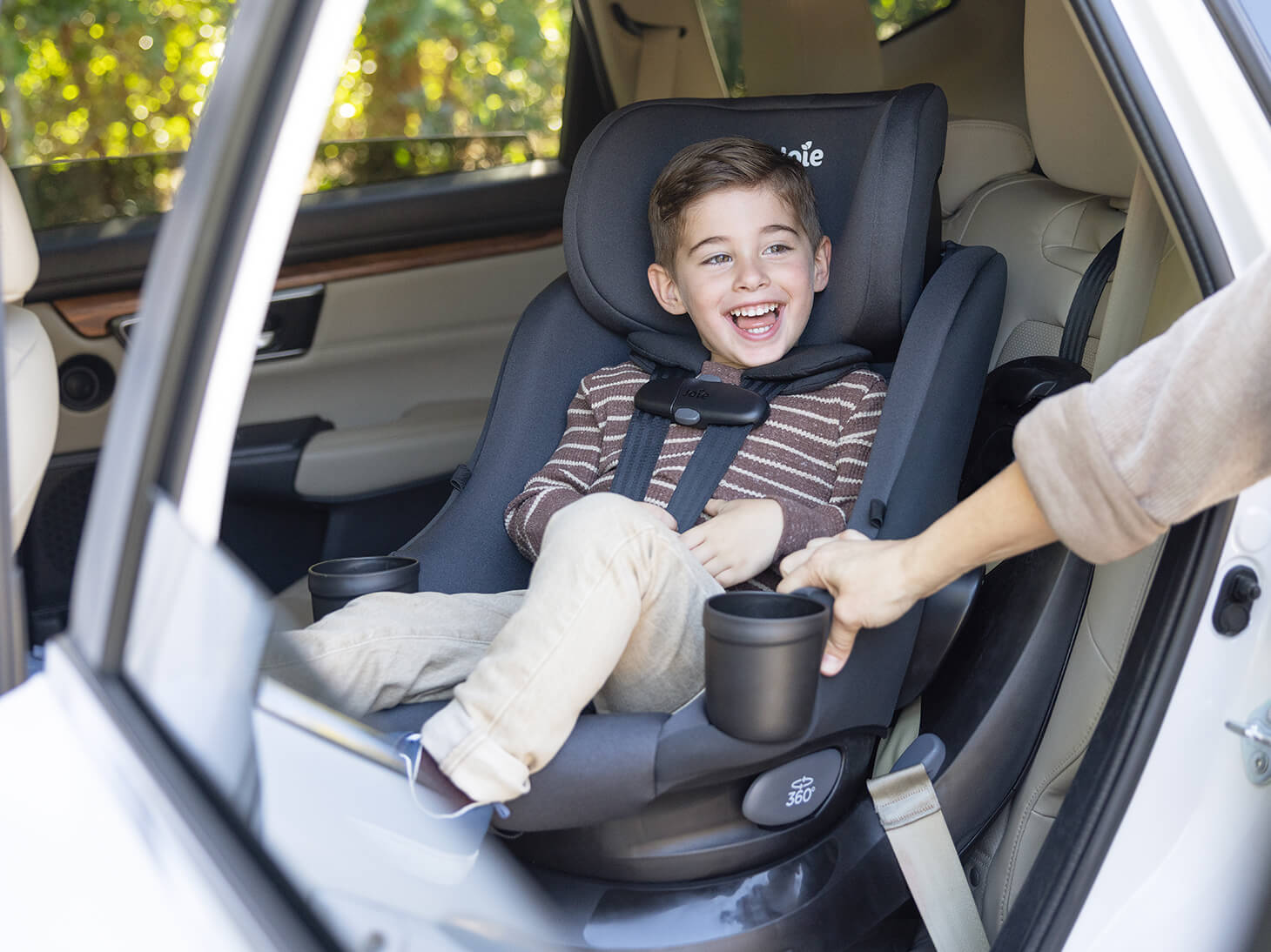 Child in chili spin SI 2-in-1 rotating car seat spinning toward outside in car