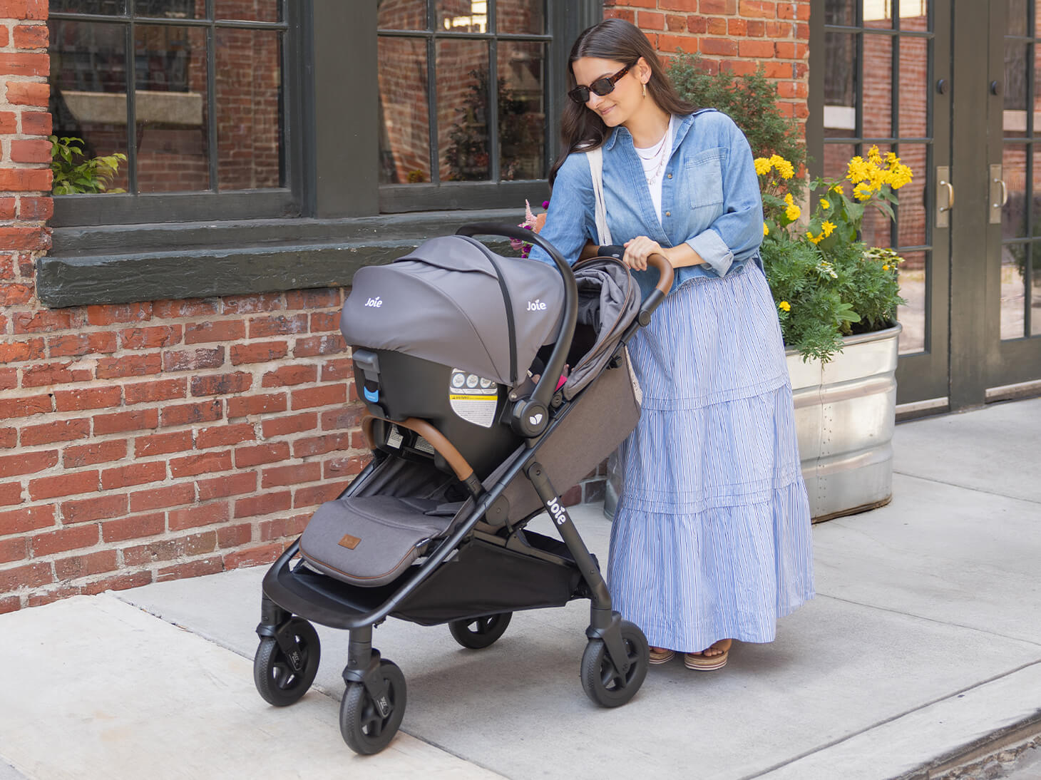 Mom walking with caraway whirl in gray with travel system
