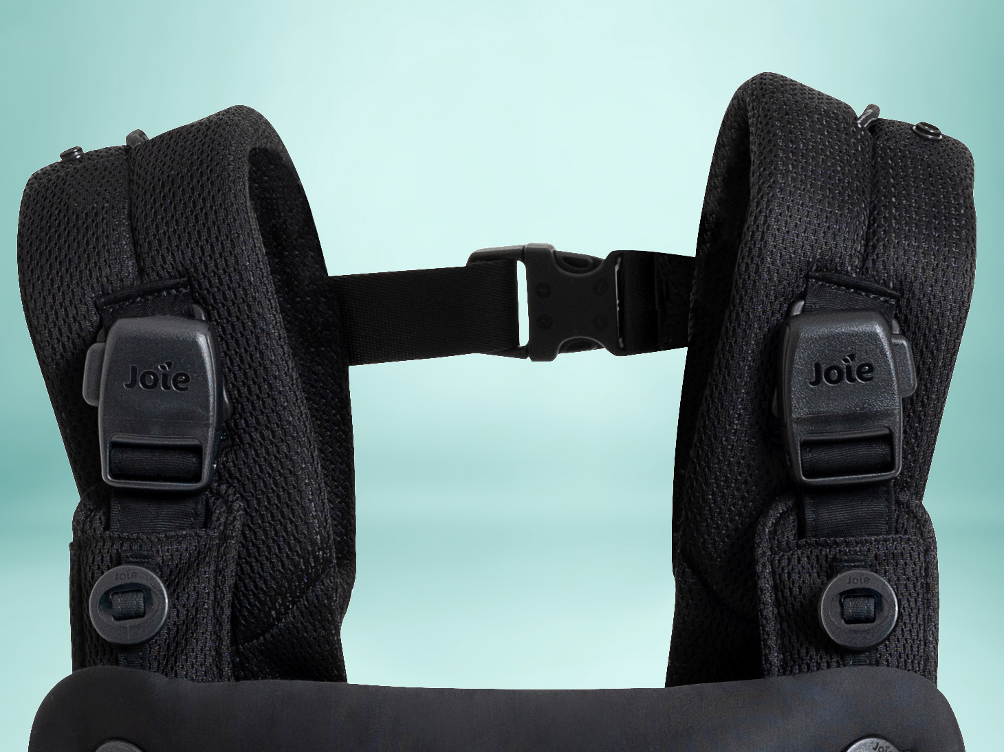 Close-up of shoulder buckles and straps of savvy 4-in-1 air carrier in coal on light blue background