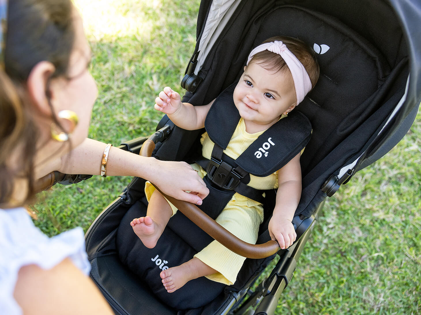 Happy baby in seat of Ginger 4-in-1 pramette to stroller in park
