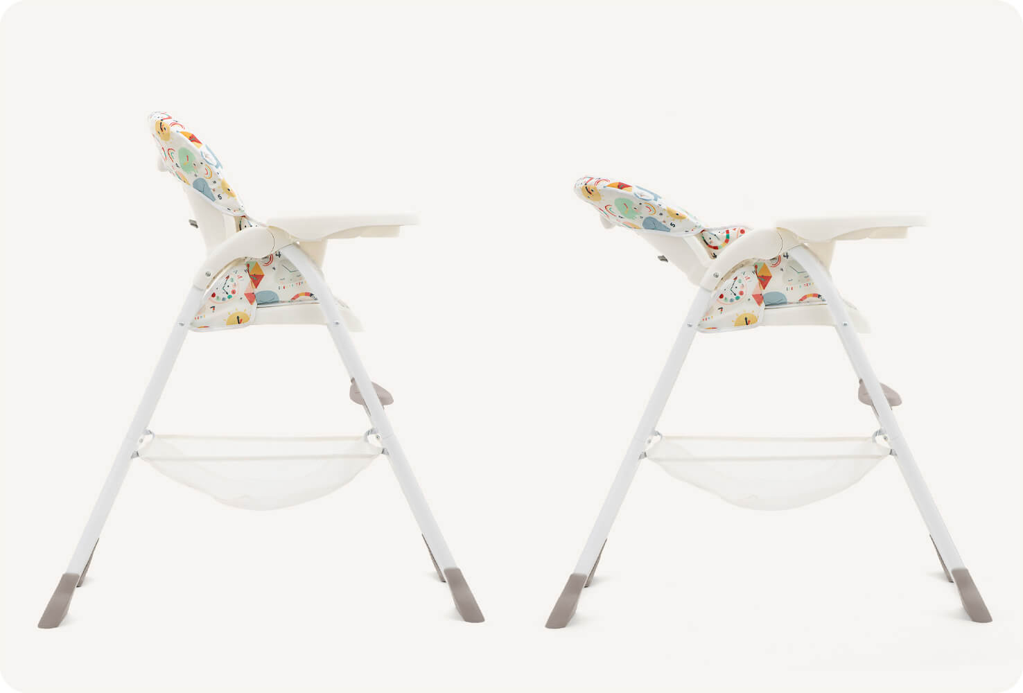  Two Joie highchairs in a multi-color print featuring cartoon clock faces, animals, and geometric shapes from a side view. One is upright and one is reclined to indicate the reclining function of the mimzy Snacker.