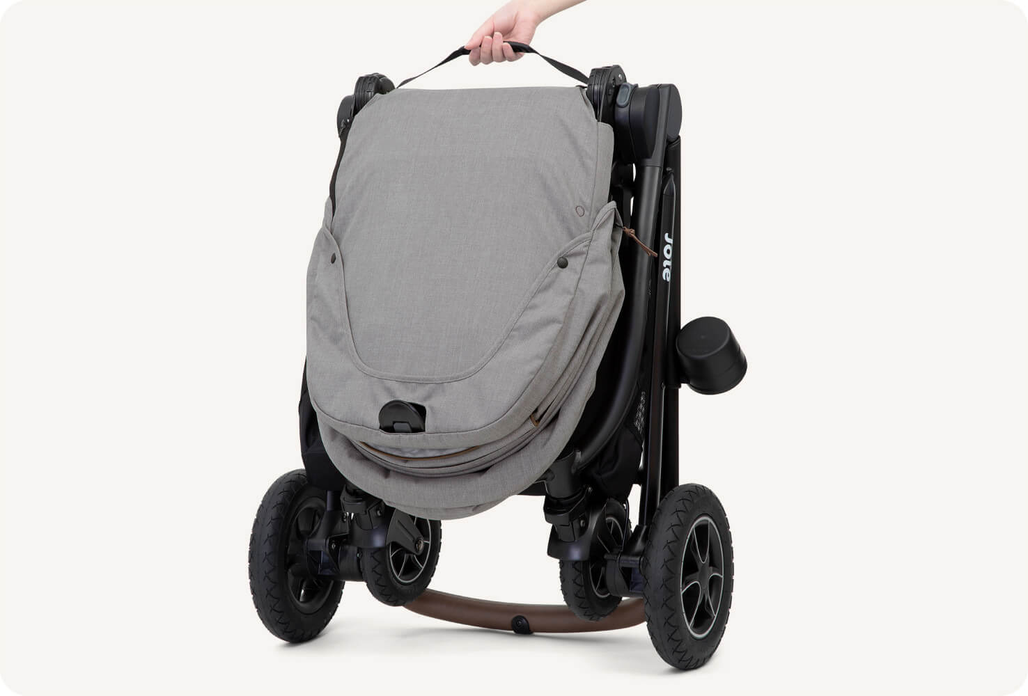  Zoomed in view of the folded light gray and black Joie versatrax pram. 