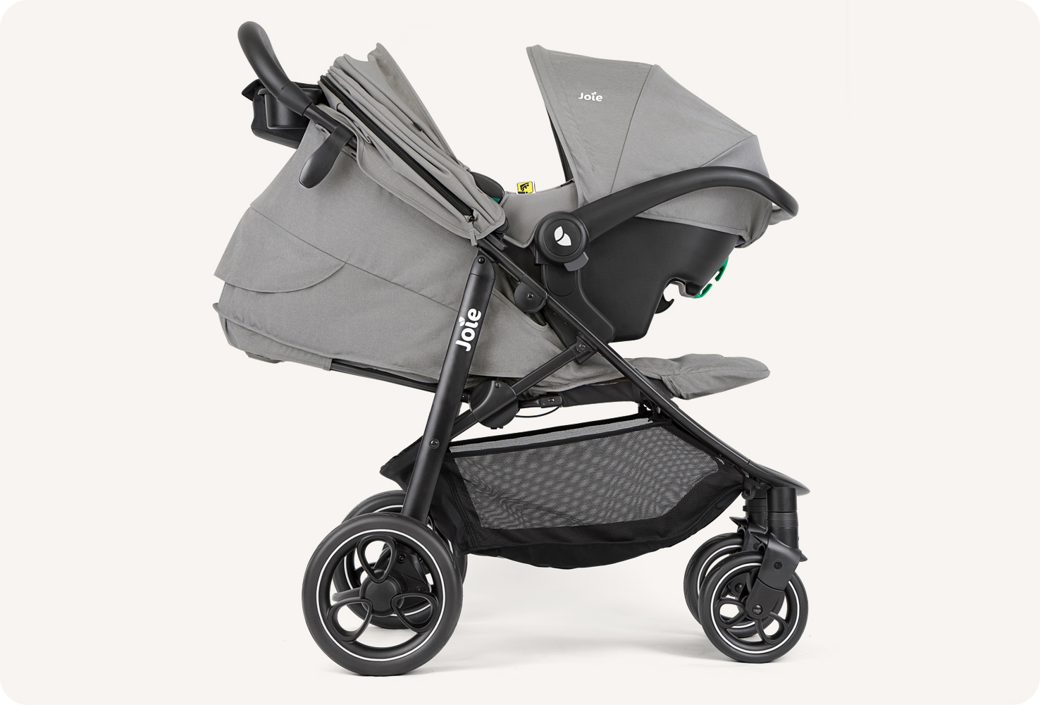   JoIe gray litetrax stroller with infant carrier. Joie litetrax 4 Kinderwagen in grau mit aufgesetzter Babyschale nach rechts.