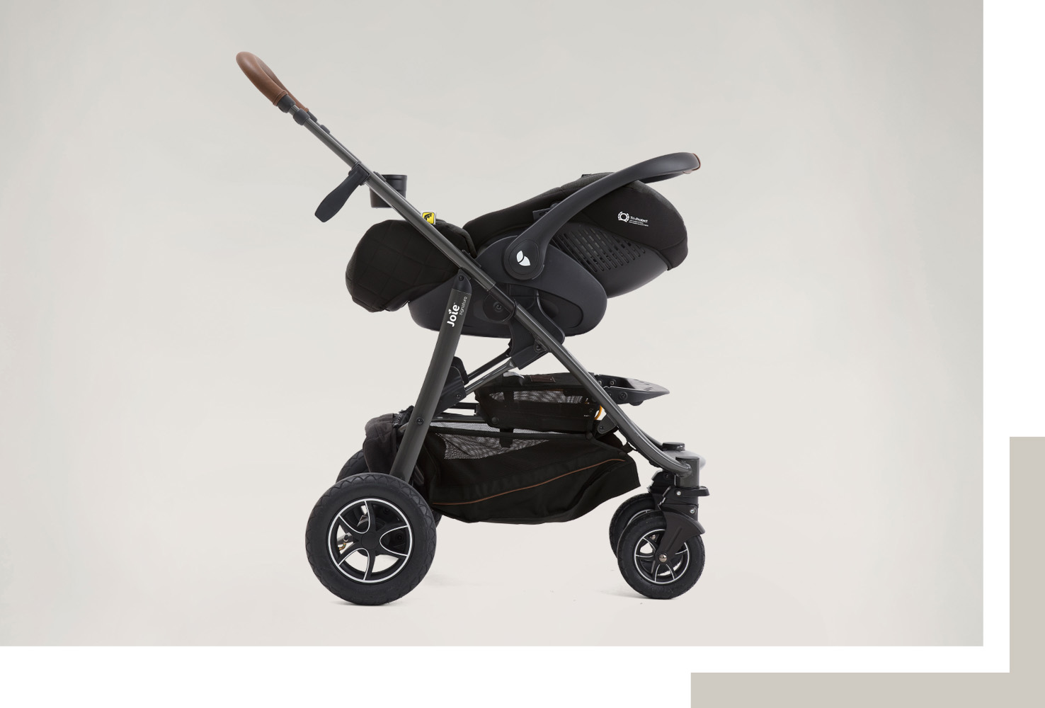 Ein Bild der Joie Signature i-Level Recline Babyschale auf einem Kinderwagen als Travel-System installiert.
