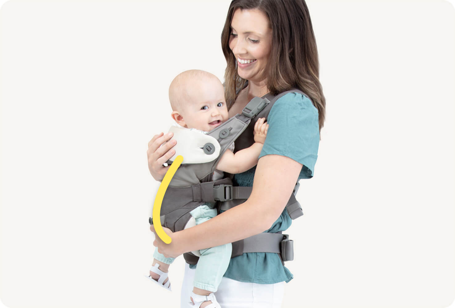 Closeup of a baby in a gray Joie Savvy Lite 3in1 baby carrier with a yellow line indicating the C shape of the baby’s spine