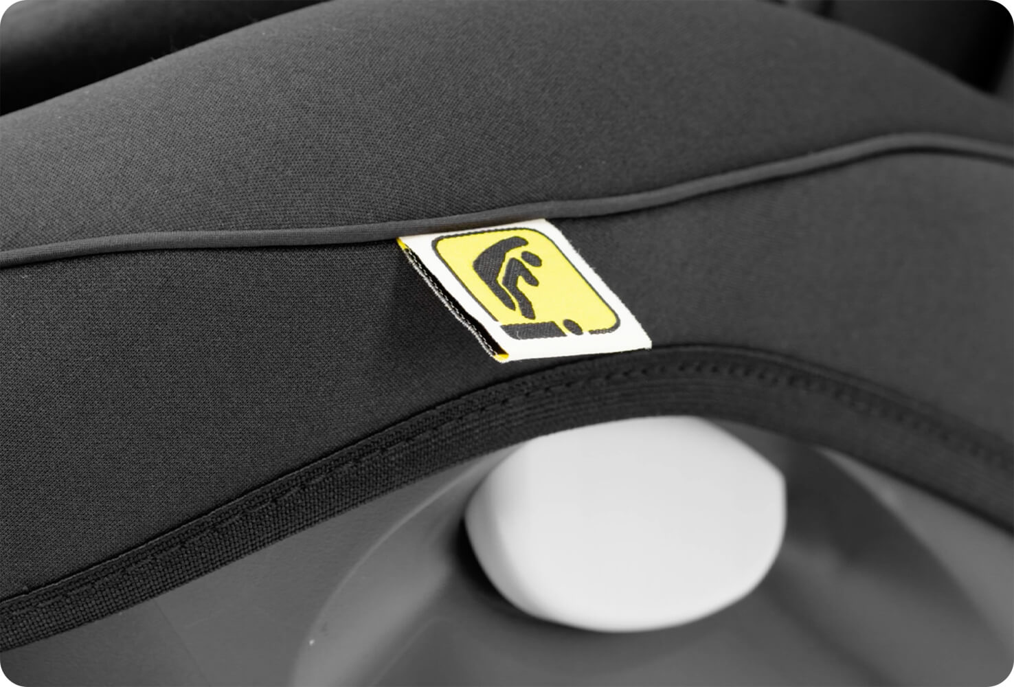 Closeup of I-Size r tag on a black Joie I-Spin Safe car seat