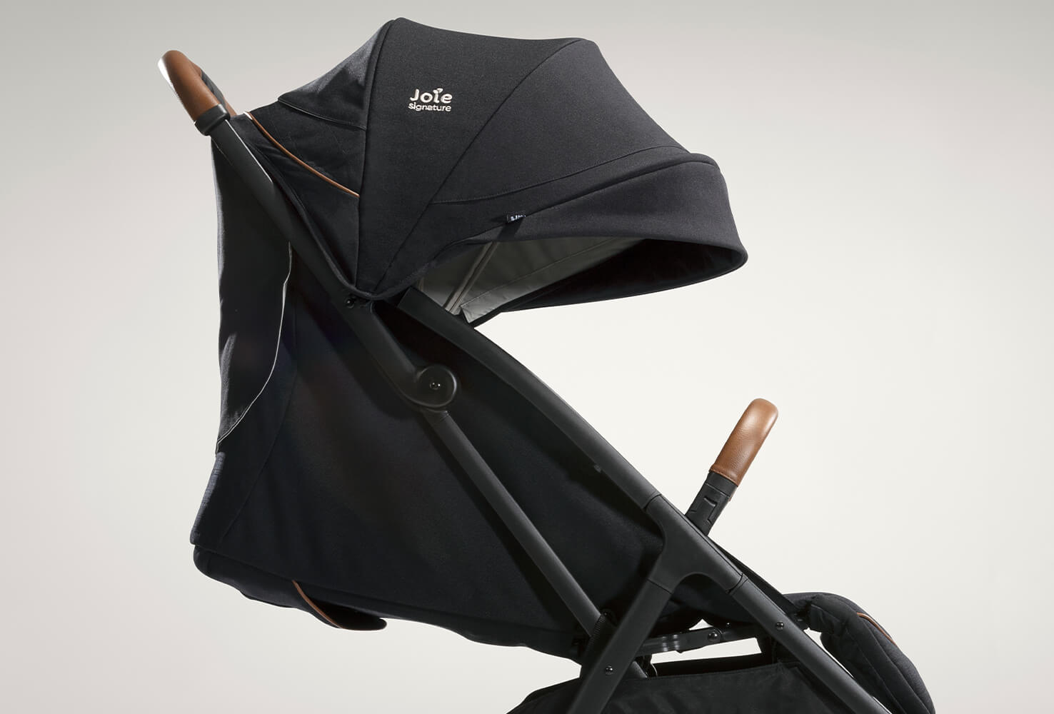 Joie signature lightweight stroller parcel in black facing right and reclined. 