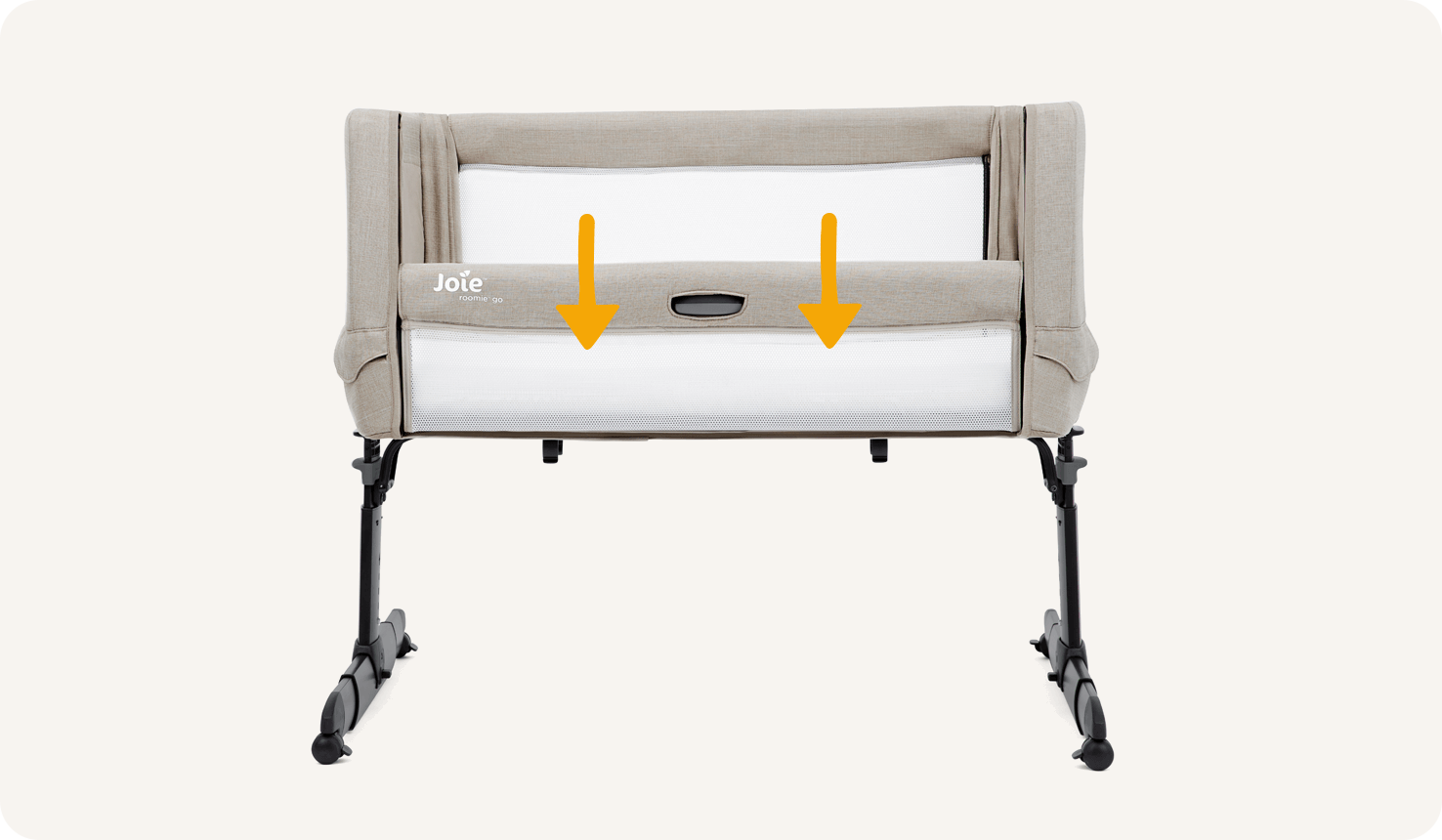 Straight on view of the Joie Roomie Go bedside crib with lift and lower side panel down. Two downward orange arrows illustrate the panel lowering.