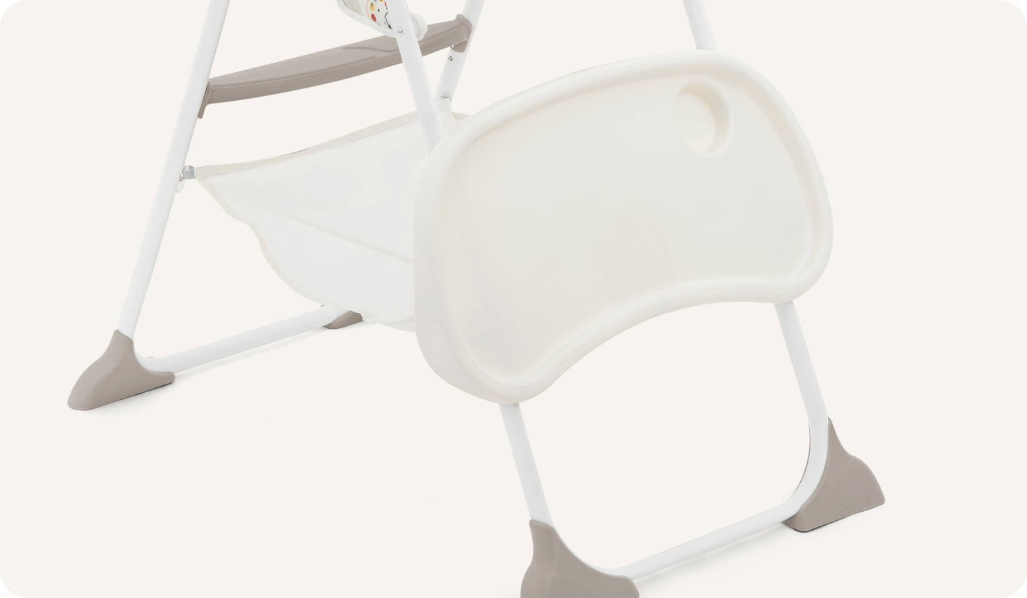  The Joie highchair mimzy Snacker in a multi-color print featuring cartoon clock faces, animals, and geometric shapes showing how the tray stores on the back legs.