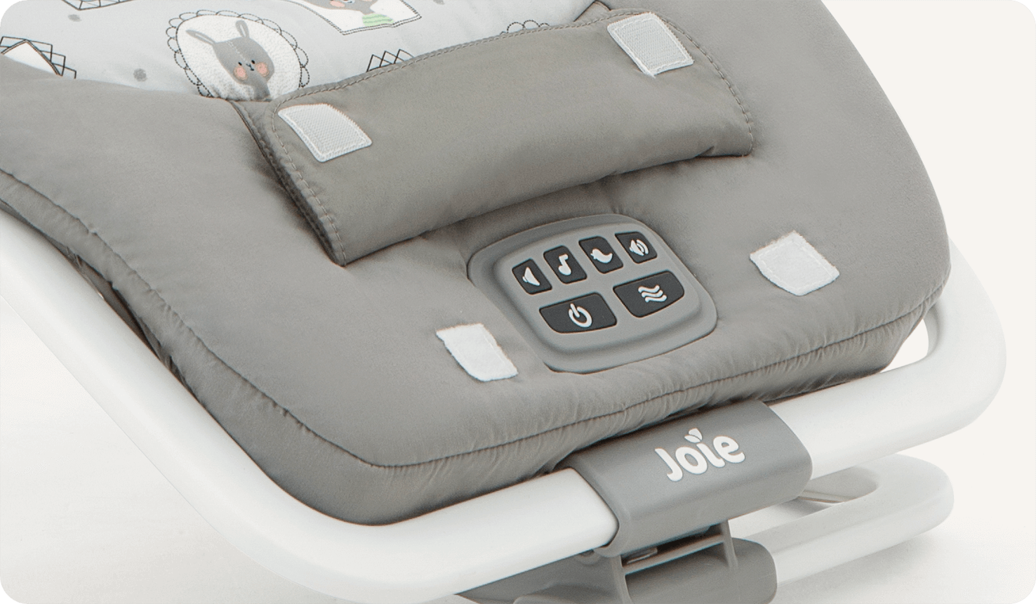 Zoomed in on music control buttons of grey patterned dreamer Joie bouncer.