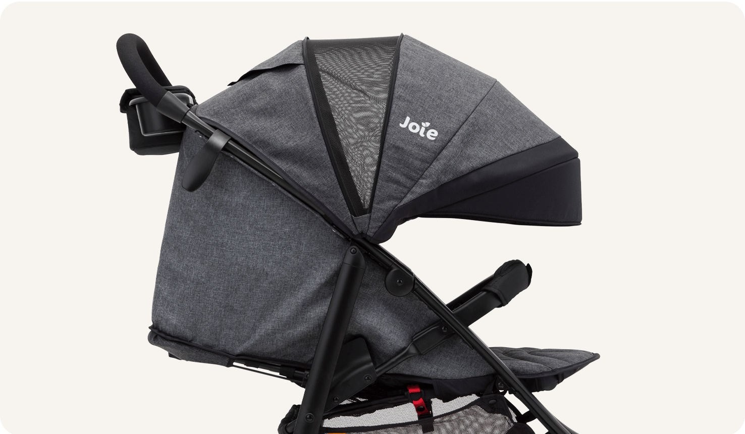  Closeup on a black Joie Litetrax 4 stroller, facing toward the right in profile, fully reclined and with the canopy extended.