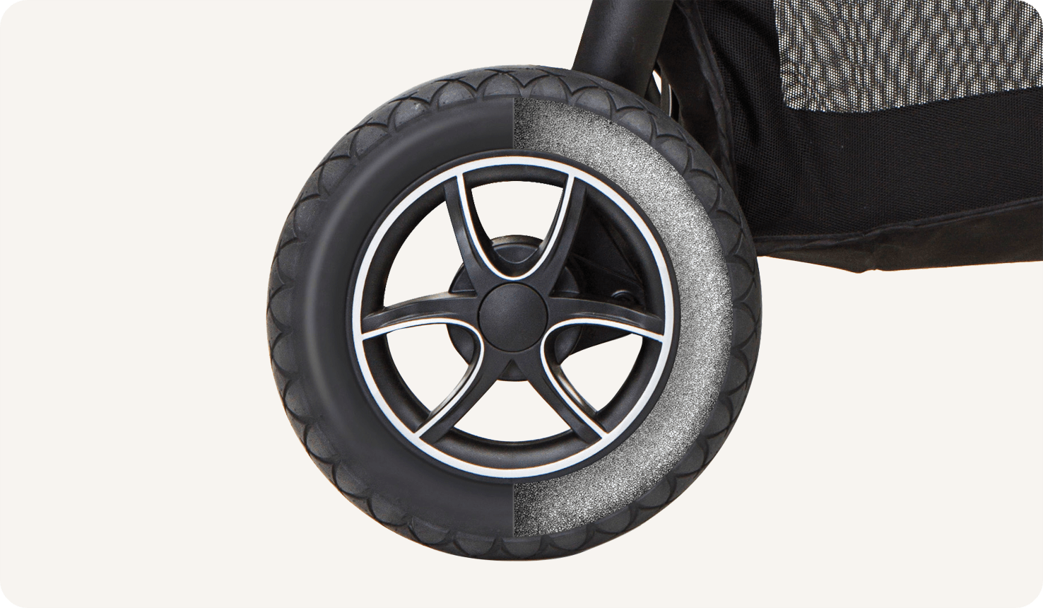 Zoomed in view of the wheel of the gray and black Joie versatrax pram. 