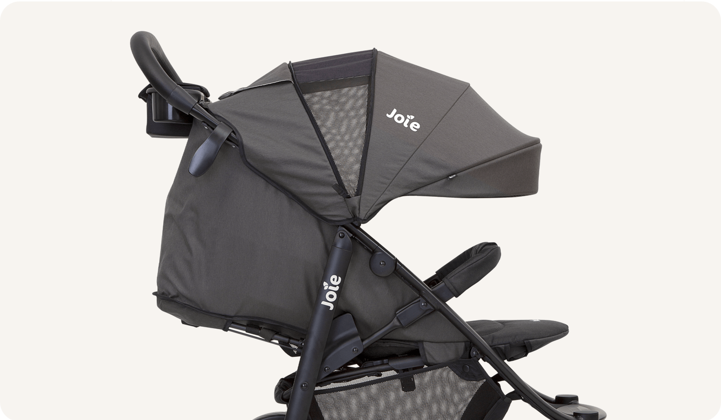 Closeup on a black Joie Litetrax 4 stroller, facing toward the right in profile, fully reclined and with the canopy extended.
