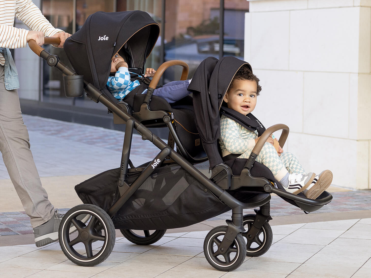 Infant and baby sitting in chive stroller in shale with chive sibling seat
