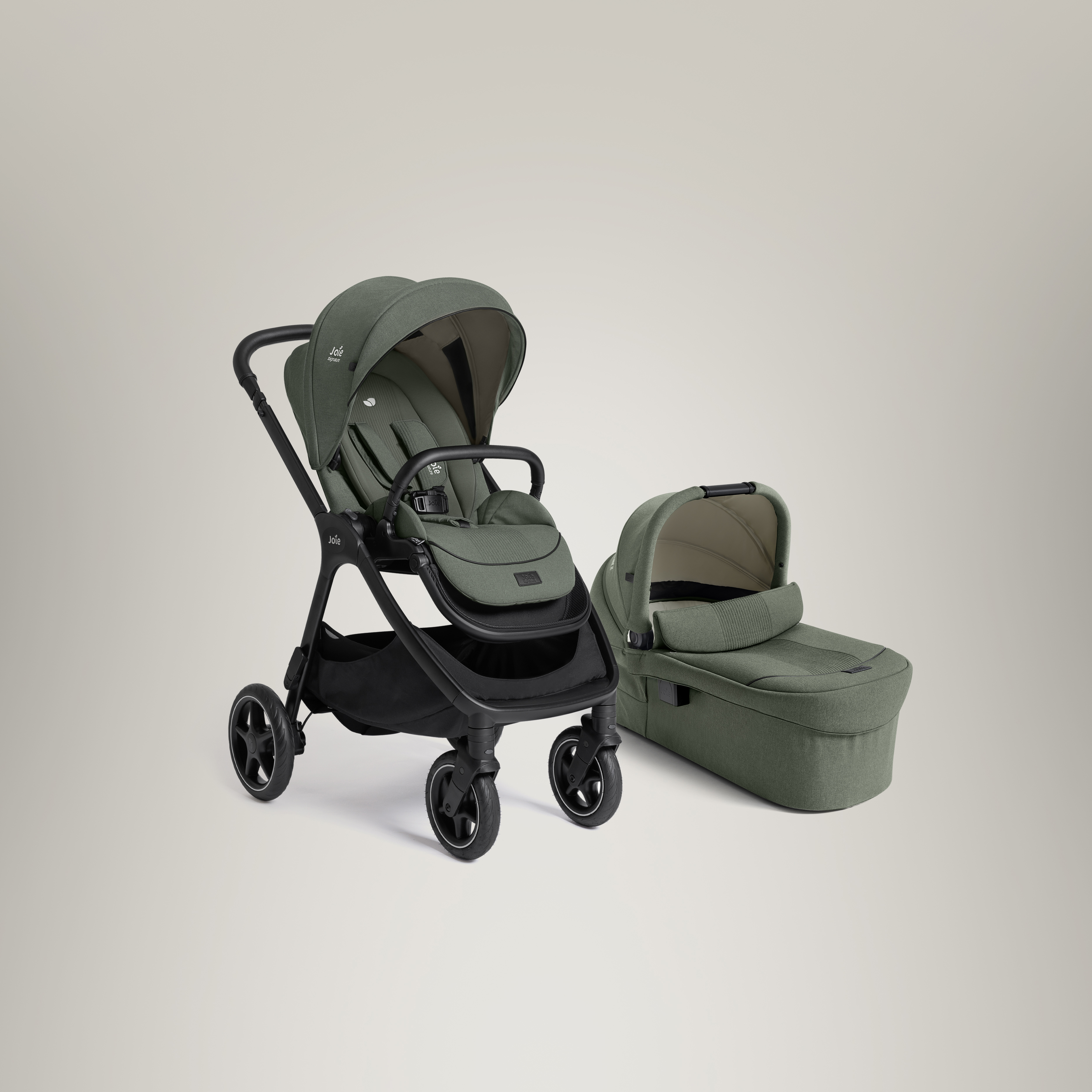 Joie Signature Finiti Kompaktkinderwagen und Ramble XL Babywanne nebeneinander im rechten Winkel abgebildet. Beide sind in Evergreen Graugrün dargestellt.
