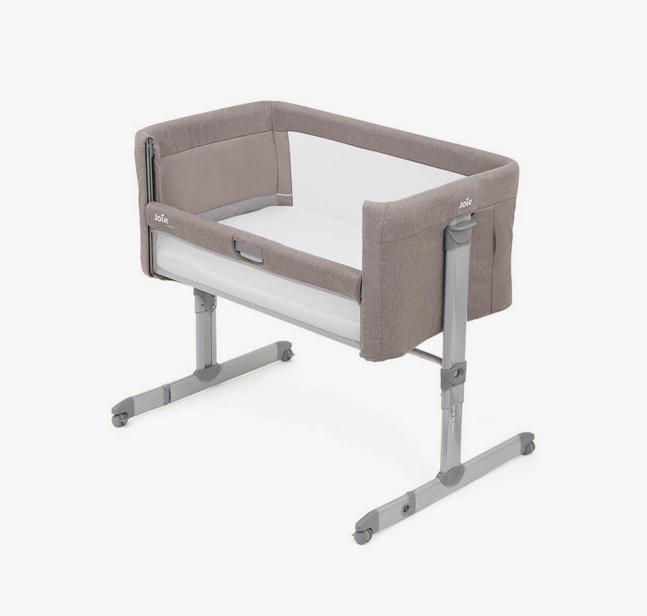 Culla fianco letto Joie roomie marrone chiaro in diagonale orientata verso destra con la spondina laterale abbassata.