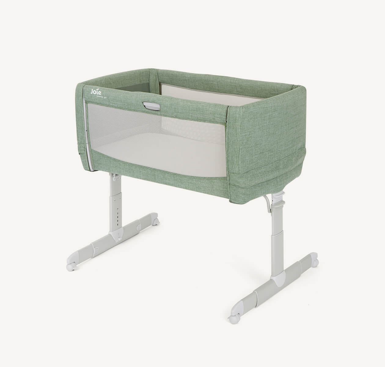 Light green Joie roomie go bedside travel crib at an angle with the drop side up.