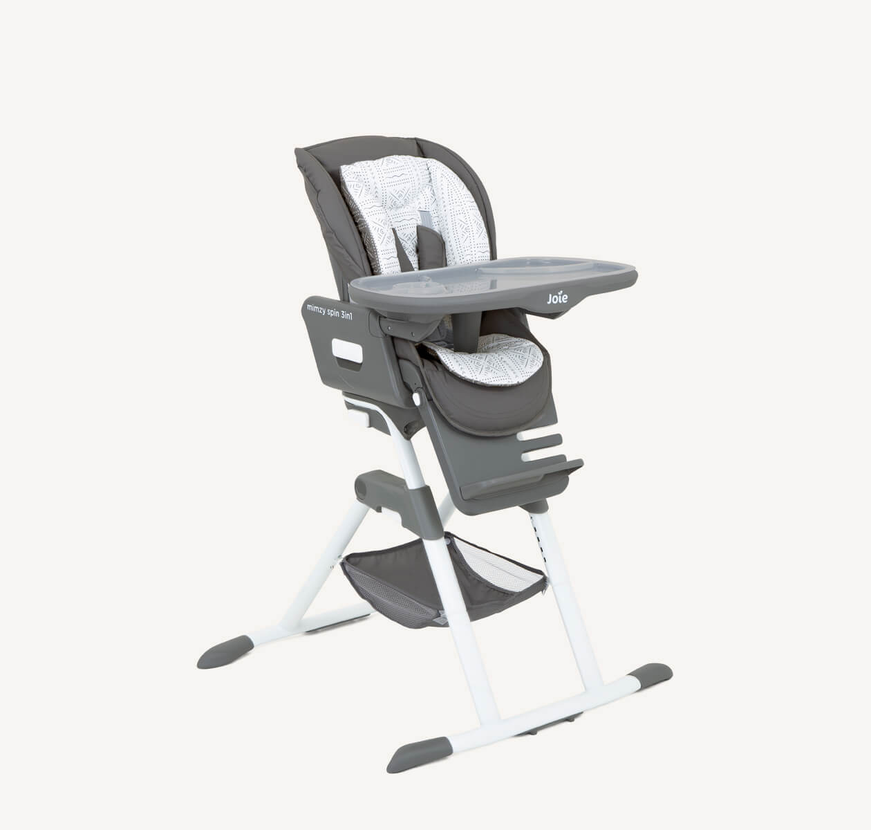 The Joie highchair Snacker 3in1 in a dark and light gray monotone geometric print from a right angle. 