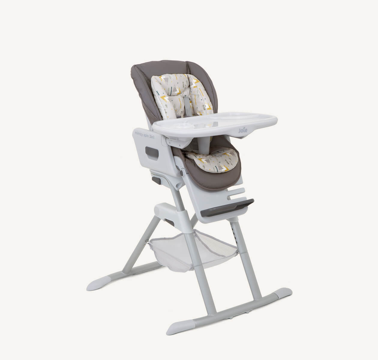 The Joie highchair mimzy Spin 3in1 in a dark and light gray print with multi-color geometric mountain shapes from a right angle. 