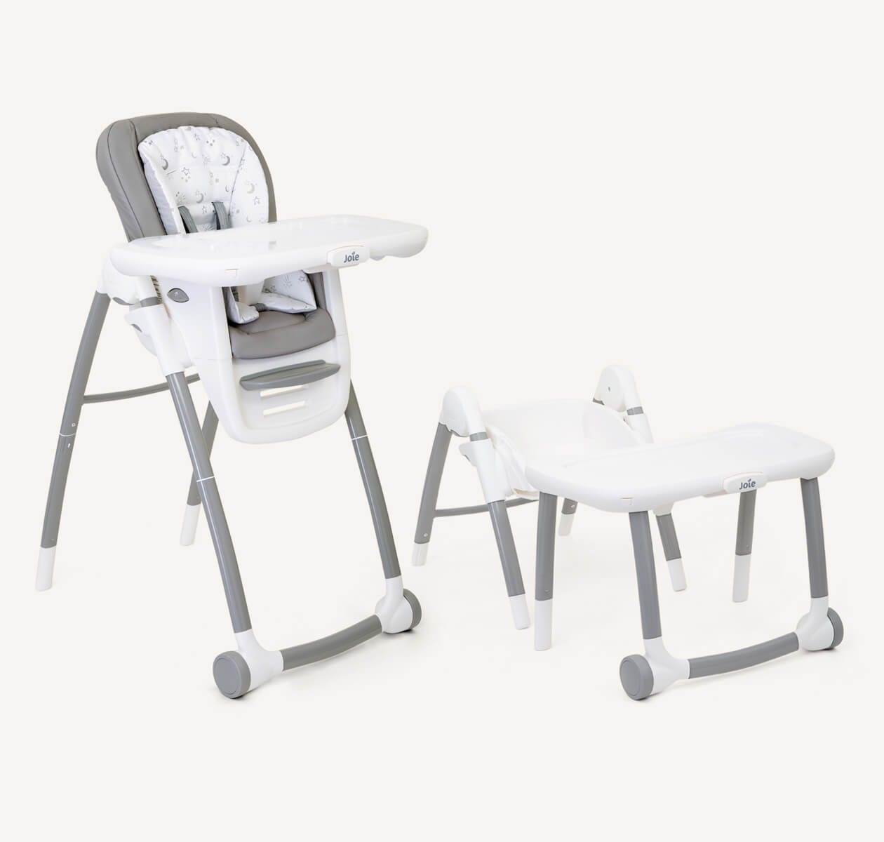 A multiply highchair with light grey and starts patterns seat, white tray with grey front wheels on a right angle.