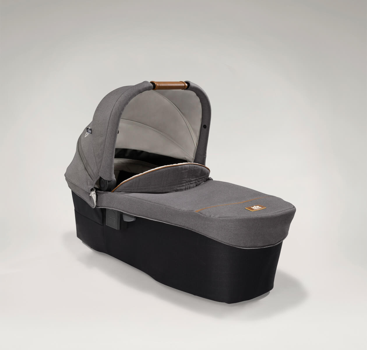 Joie Signature ramble xl carry cot in dark and light gray at a right angle with hood raised.