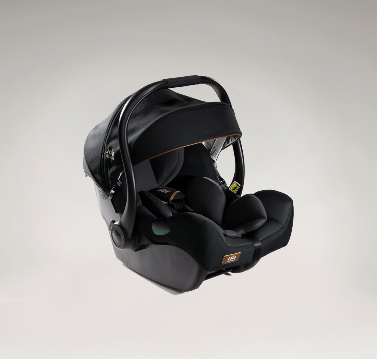 A black Joie i-Jemini infant car seat at an angle facing to the right