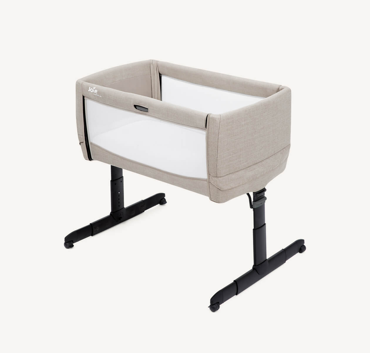   Tan Joie roomie go bedside travel crib at an angle with the drop side raised.