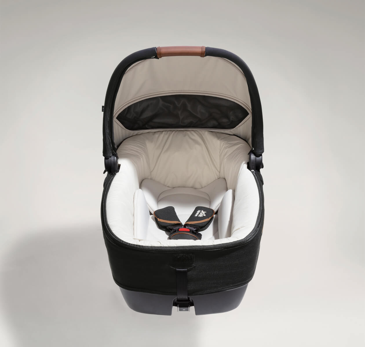 Joie Signature calmi R129 car cot in the color black eclipse facing front with protective cover off