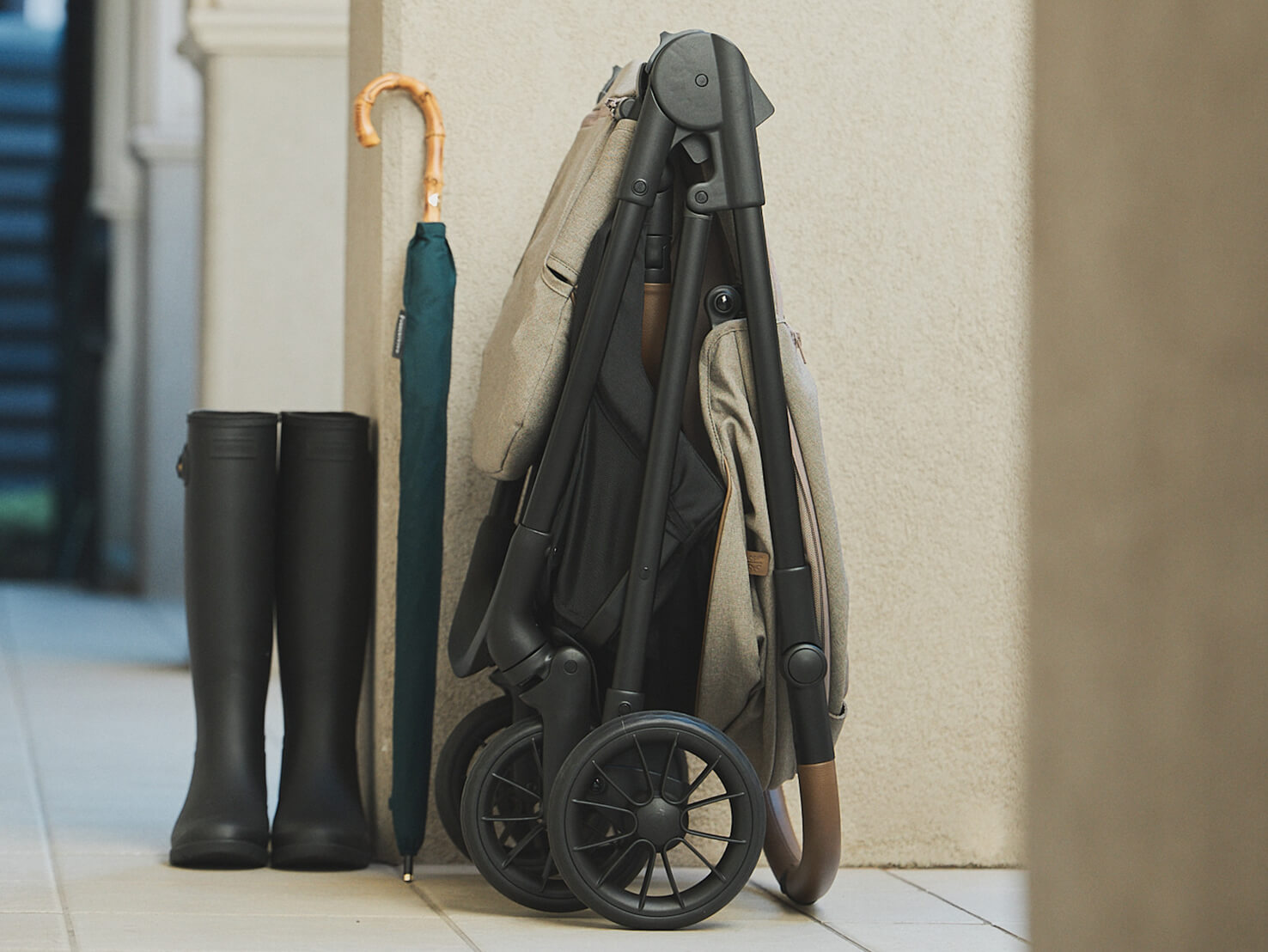 Folded elipto pram shown in a compact form in an appartment entranceway