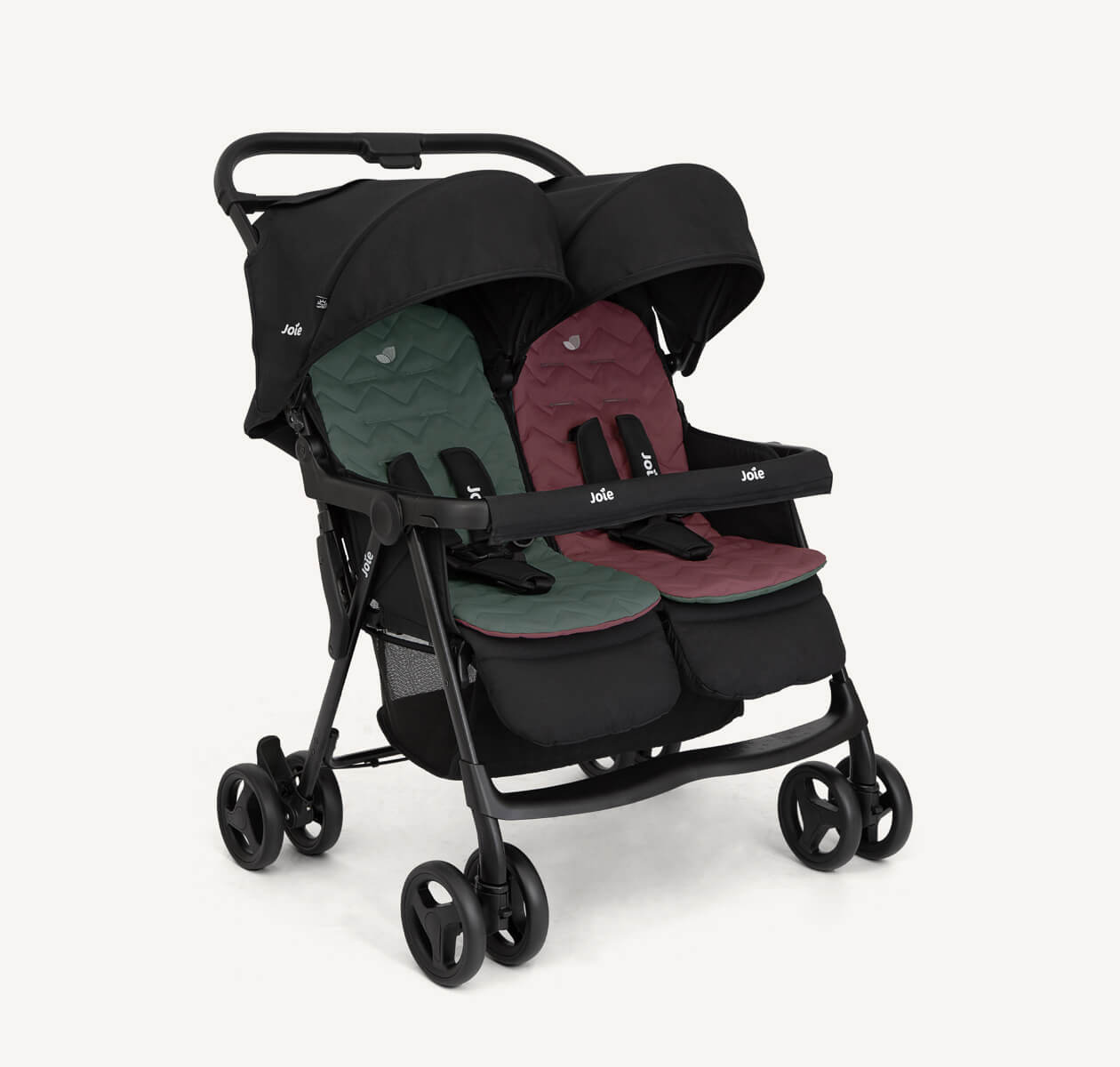  The Joie Aire Twin side-by-side double stroller in black at an angle, with a sage coloured seat insert on the left seat and a dark pink coloured seat insert on the right seat.
