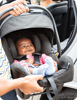 Bebé pequeño en la silla de coche y portabebés Joie i-Gemm 3