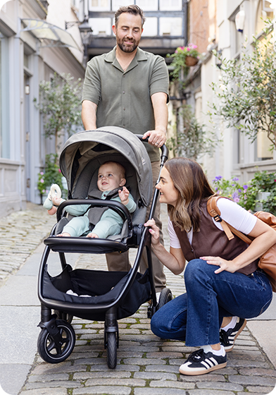 Großaufnahme eines glücklichen Babys im grauen Joie Signature Finiti.