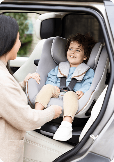 Enfant installé dans le rehausseur de siège auto à dossier haut Joie iTrillo