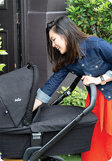 Mother teasing her baby in the chrome™ dlx and carry cot