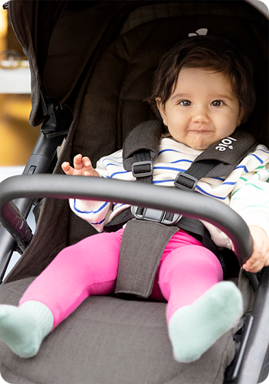 Bébé assis dans une poussette Mytrax Pro grise