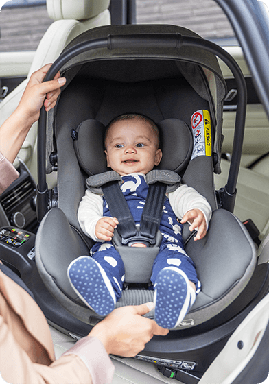 Miminko se usmívá v autosedačce Joie i-Level Pro uvnitř auta.