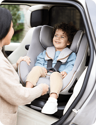 Enfant installé dans le rehausseur de siège auto à dossier haut Joie iTrillo