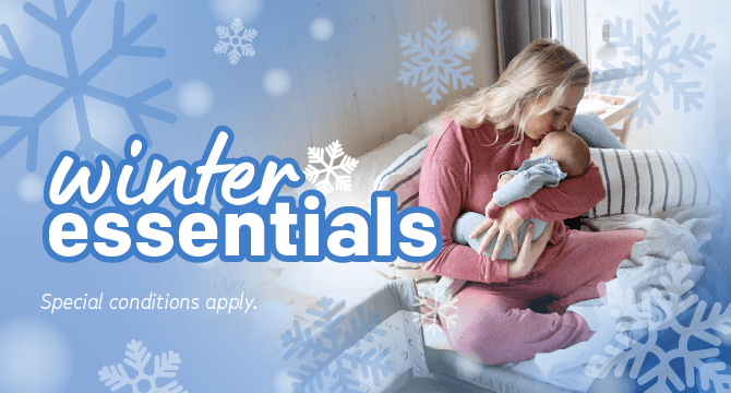 image of a mother holding baby snuggled in bed with text referencing winter essentials 