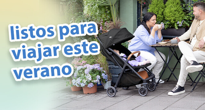 Padres charlando tomando caf&eacute; en una mesa de cafeter&iacute;a en un jard&iacute;n al aire libre. El beb&eacute; est&aacute; relajado c&oacute;modamente a su lado en el cochecito Joie pact pro. El texto en la imagen destaca los imprescindibles para viajar en verano.