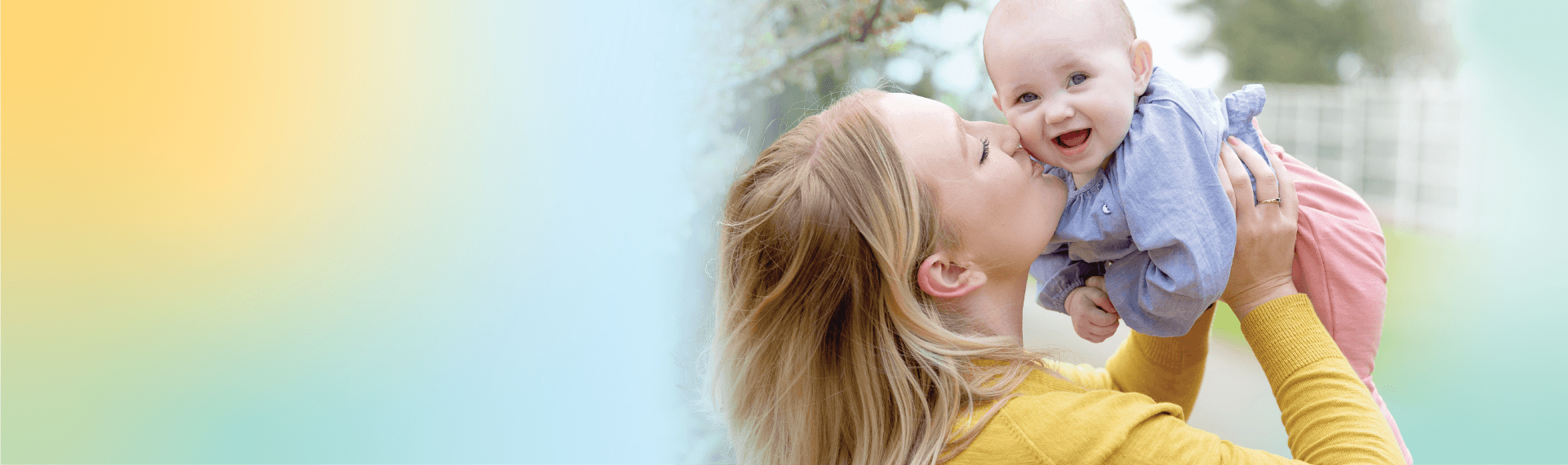 Mama strahlt und hält ihr fröhliches Baby in die Luft – dazu gibt’s alle Infos zum Sommer-Sale von Joie.