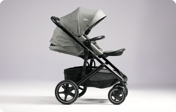 Poussette Joie elara grise, vue de profil orient&eacute;e vers la droite, sur fond violet.