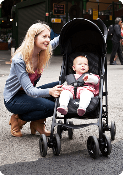 The mother crouched next to the baby in the Joie Nitro stroller